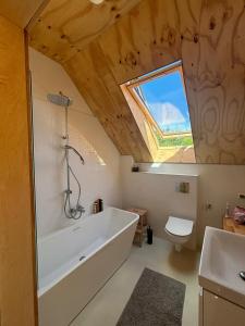 ein Badezimmer mit Badewanne und Toilette und einem Fenster in der Unterkunft Elegant holiday residence with privat sauna close to Baltic Sea on Wolin Island in Wisełka