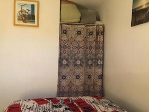 a bedroom with a bed with a curtain on the wall at Résidence CAP HORN ,13 ter Avenue des Élysées in Valras-Plage
