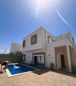 ein Haus mit einem Swimmingpool davor in der Unterkunft Villa shadow in Mezraya