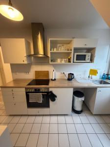 a kitchen with white cabinets and a stove top oven at Monteurzimmer Schölerpad in Essen
