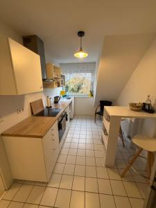 a kitchen with white cabinets and a tile floor at Monteurzimmer Schölerpad in Essen