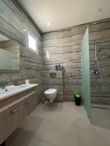 ein Badezimmer mit Toilette, Waschbecken und Dusche in der Unterkunft Villa shadow in Mezraya