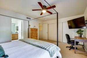 土桑Family Home with Fenced Yard in Tucson!的一间卧室配有一张带吊扇的床和一张书桌。