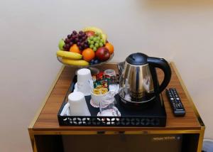 a table with a bowl of fruit and a tea kettle at Rizkian pyramids view INN in Cairo +23 photos