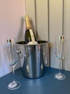 a bottle of champagne in a bucket next to two wine glasses at ECOLETRAS LOFT CONTAINER - SÃO THOMÉ DAS LETRAS Mg in São Thomé das Letras