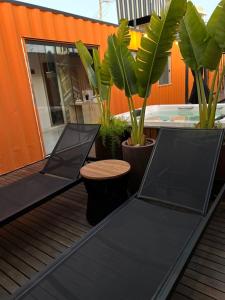 a black table on a deck with plants at ECOLETRAS LOFT CONTAINER - SÃO THOMÉ DAS LETRAS Mg in São Thomé das Letras