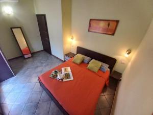 a bedroom with a red bed with two plates of food on it at Al 28в, Appartamento Teulada in Teulada