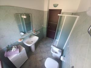 a bathroom with a sink and a toilet and a mirror at Al 28в, Appartamento Teulada in Teulada