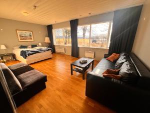 a living room with a couch and a bed at Hlíðarból Guesthouse in Hvolsvöllur