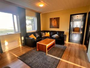 a living room with a couch and a coffee table at Hlíðarból Guesthouse in Hvolsvöllur