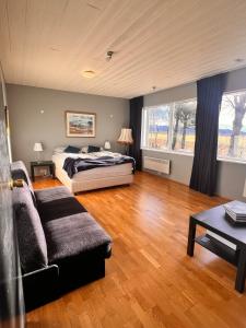a large bedroom with a bed and a couch at Hlíðarból Guesthouse in Hvolsvöllur