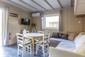 ein Wohnzimmer mit Tisch und Couch in der Unterkunft Chalet 809 tout confort en lisière de forêt in La Teste-de-Buch