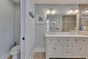 ein weißes Badezimmer mit Waschbecken und Toilette in der Unterkunft Great Escape in Kure Beach + 37 Fotos