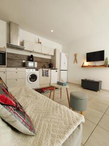 阿克斯莱泰尔姆Appartement centre Ax-les-Thermes proche télécabines & parking的厨房配有白色橱柜、沙发和桌子