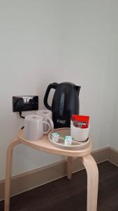 een tafel met een koffiepot en kopjes erop bij London Grand in Londen