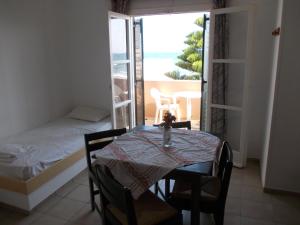 a room with a table and a bed and a balcony at Pelamare in Kokkini Khanion