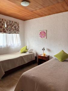 une chambre d'hôtel avec deux lits et une fenêtre dans l'établissement Marae - Cabañas Premium, à Hanga Roa