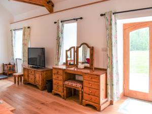 a room with a dresser with a mirror and a television at Slade Cottage - Uk35027 in Highbray