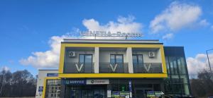 ein gelbes und weißes Gebäude mit einem Schild darauf in der Unterkunft VENETIA-Rooms in Biecz