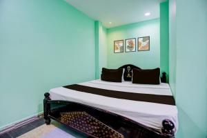 a bedroom with a bed in a blue room at Hotel O Surya Lodge in Guntūr