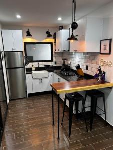 - une cuisine avec des placards blancs, une table et un réfrigérateur dans l'établissement Casa de descanso, con Alberca climatizada, à Coyula