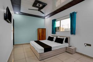 MurādnagarにあるHotel O Sukoon Guest Houseのベッドと天井扇風機のある寝室