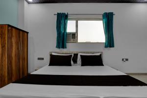 MurādnagarにあるHotel O Sukoon Guest Houseのベッドルーム1室(青いカーテン付きの大型ベッド1台付)