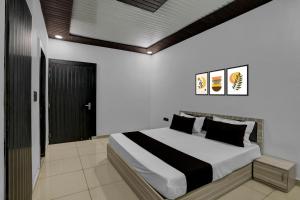 MurādnagarにあるHotel O Sukoon Guest Houseのベッドルーム(白い大型ベッド、黒い枕付)