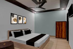 MurādnagarにあるHotel O Sukoon Guest Houseのベッドと天井扇風機のある寝室