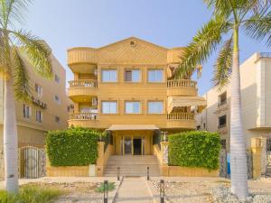 Un gran edificio con palmeras delante. en Villa 53 Hotel Luxury Suites by Pharaohs Hospitality, en Sheikh Zayed