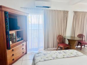 ein Schlafzimmer mit einem Bett und einem Tisch und Stühlen in der Unterkunft Tropicana Hotel Puerto Vallarta in Puerto Vallarta