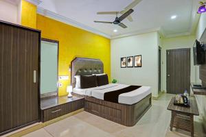 Un dormitorio con una cama grande y un televisor. en Collection O Machilipatnam Bus Terminal Formerly Vijaya Raghava Residency, en Machilīpatnam