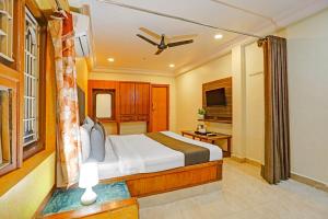 una habitación de hotel con una cama y un televisor en Collection O Machilipatnam Bus Terminal Formerly Vijaya Raghava Residency, en Machilīpatnam