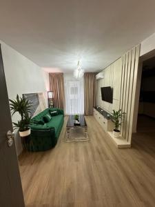 un salon avec un canapé vert et une télévision dans l'établissement Pipera Luxury Suite - Victoria Homes, à Voluntari 4 autres photos