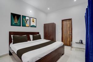 une chambre avec un grand lit dans une pièce dans l'établissement Hotel O SGT University Road Formerly Budhera, à Dhankot