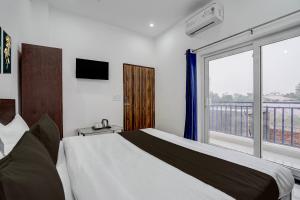 une chambre avec un lit et une grande fenêtre dans l'établissement Hotel O SGT University Road Formerly Budhera, à Dhankot