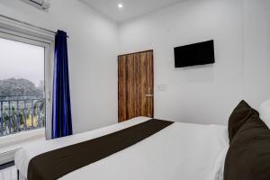 une chambre avec un lit blanc et une fenêtre dans l'établissement Hotel O SGT University Road Formerly Budhera, à Dhankot