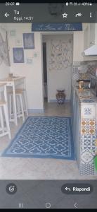 una cucina con un tappeto blu e bianco sul pavimento di Le Stanze del Mare - B&B a Messina Altre 20 foto