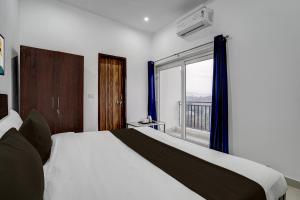 une chambre avec un lit et une grande fenêtre dans l'établissement Hotel O SGT University Road Formerly Budhera, à Dhankot