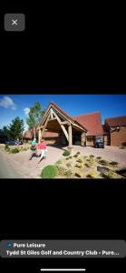 dos personas caminando frente a un edificio en Grahams Lodge, en Tydd Saint Giles