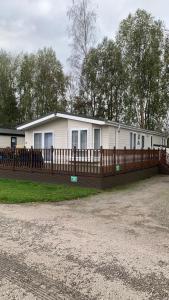 una casa con una valla de madera delante de ella en Grahams Lodge, en Tydd Saint Giles