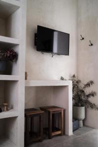 a living room with a fireplace with a tv on the wall at L'Ulivo e il Melograno - Mediterranean Studios in Frattamaggiore +35 photos