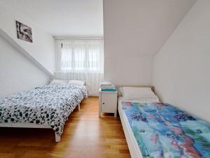 een slaapkamer met twee bedden en een raam bij Joli appartement de 3 pièces in Saint-Imier