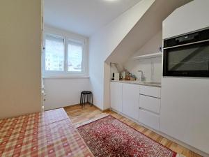 a kitchen with white cabinets and a large window at Joli appartement de 3 pièces in Saint-Imier