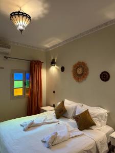 ein Schlafzimmer mit einem großen Bett mit weißer Bettwäsche in der Unterkunft Riad Le Bijou de Zahra Marrakech Kasbah in Marrakesch + 40 Fotos
