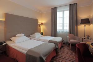 ein Hotelzimmer mit zwei Betten und einem Fenster in der Unterkunft Hotel Branicki in Białystok