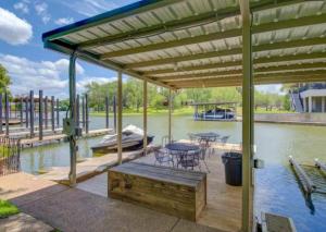 a pavilion with a table and chairs on the water at Waterfront Getaway Lake Access Deck BBQ Grill in Kingsland
