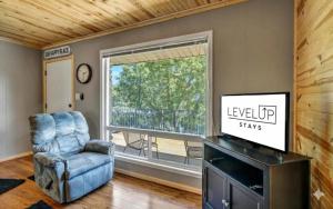 a living room with a television and a chair and a window at Waterfront Getaway Lake Access Deck BBQ Grill in Kingsland