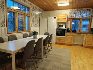 una cucina e una sala da pranzo con tavolo e sedie di Spacious Apartment for 12 with Sauna a Laitasaari