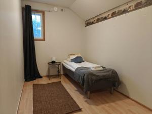 una piccola camera da letto con un letto e una finestra di Spacious Apartment for 12 with Sauna a Laitasaari